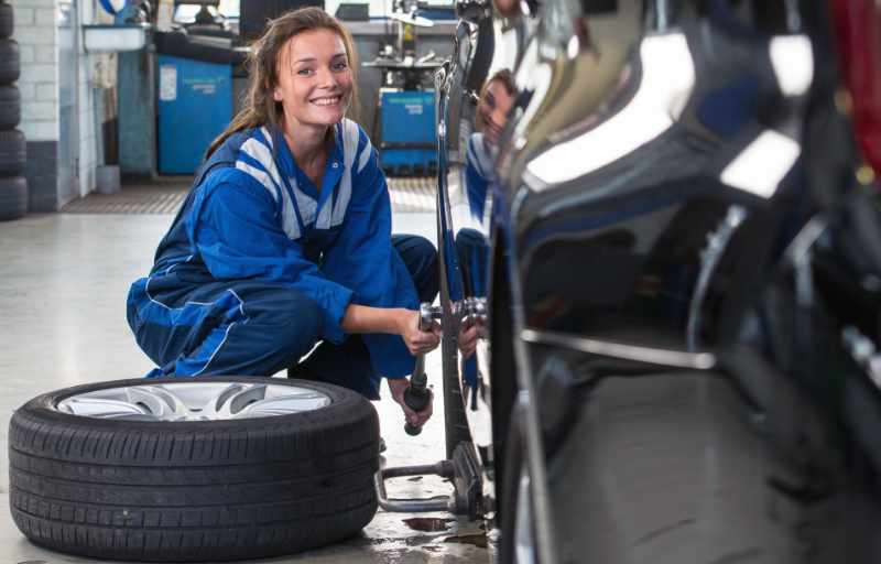 Automechanikerin beim Reifenwechsel